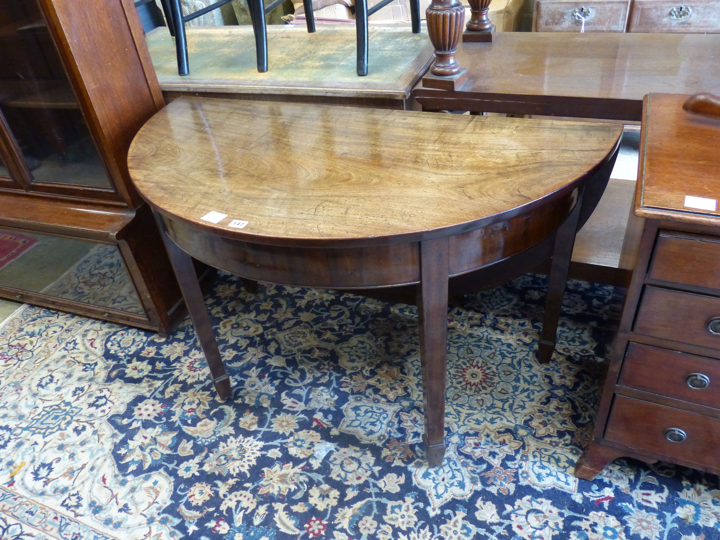 A George III mahogany demi lune drop flap dining table, length 116cm extended, width 118cm, height 71cm